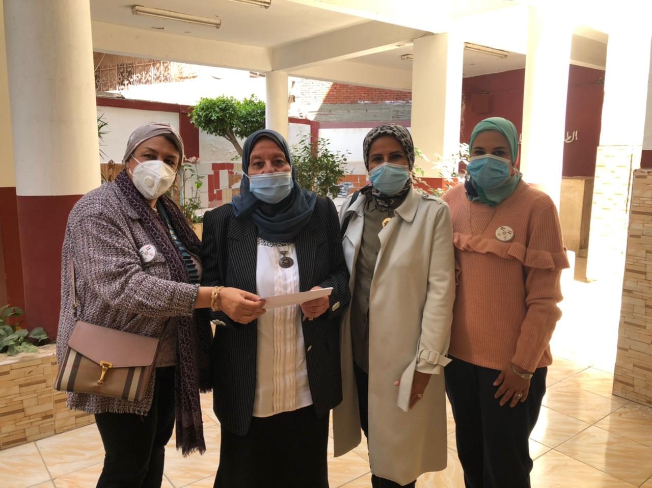 1- President of IWC of Al Mansoura presenting a check as a donation to the association