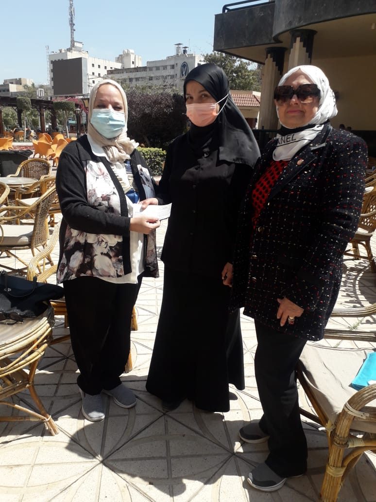 1- The President of the IWC of Tanta donate a check to a breadwinner woman